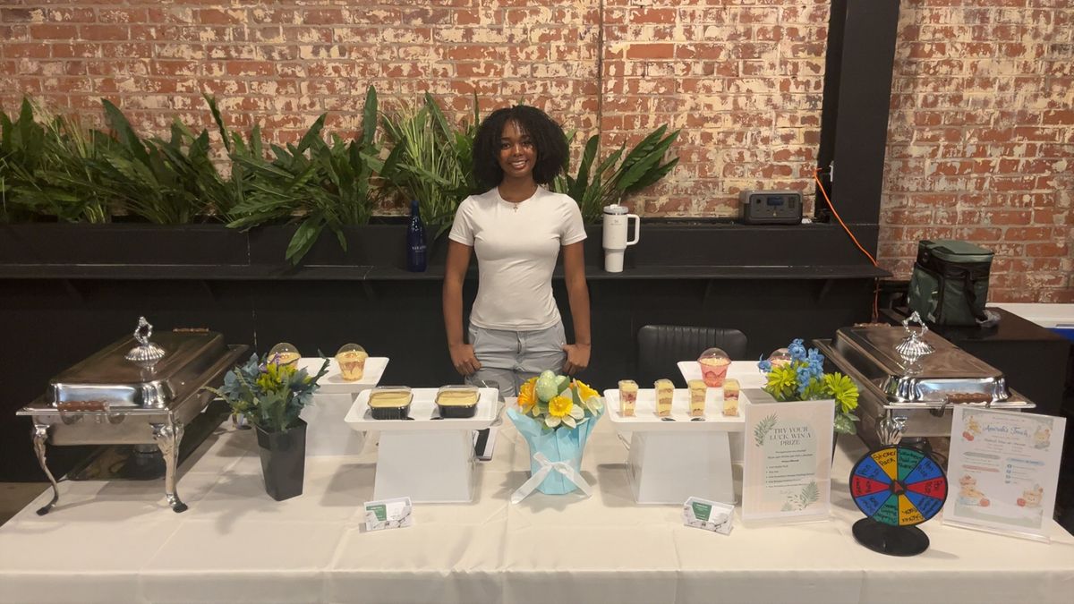 Amirah smiling at her catering table setup